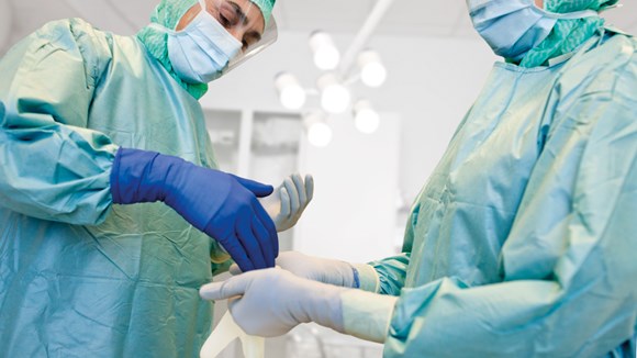 Surgeons donnning gloves